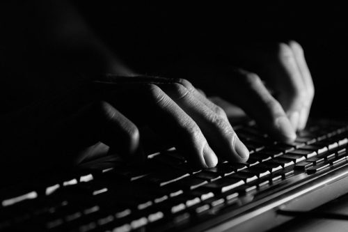 Fingers on laptop keyboard